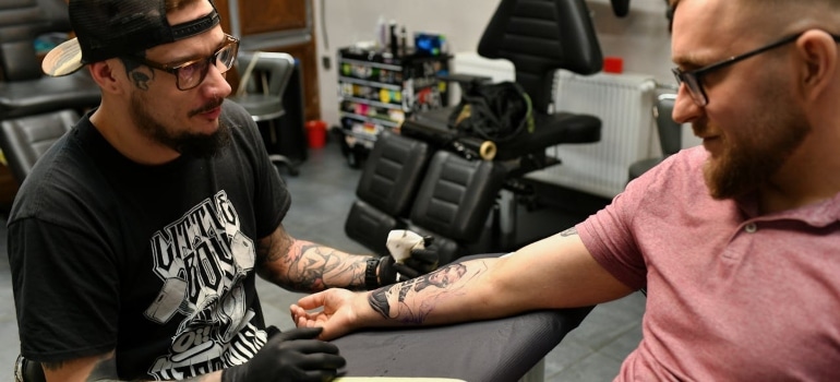 a tattoo artist talking to a customer about moving a tattoo studio