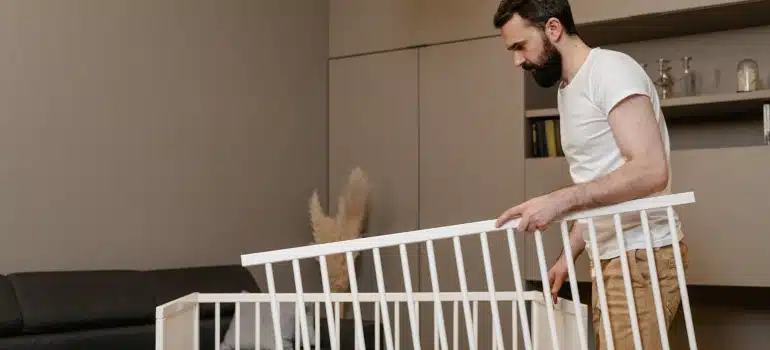 Man Setting Up a Dismantled Baby Crib