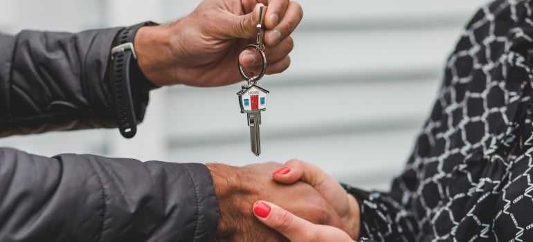 a man handing the keys to a woman