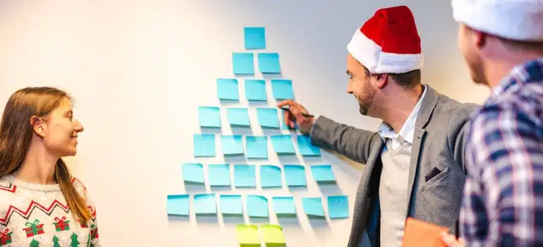 people in office wearing Santa Clause caps and planning about moving your office during the Christmas holidays. 