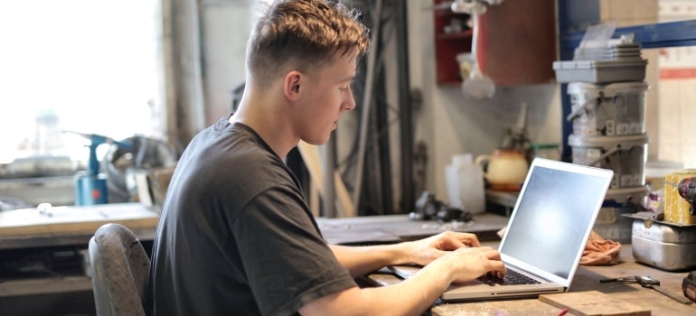 a man working on a laptop in a garage