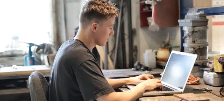 a man working on a laptop in a garage
