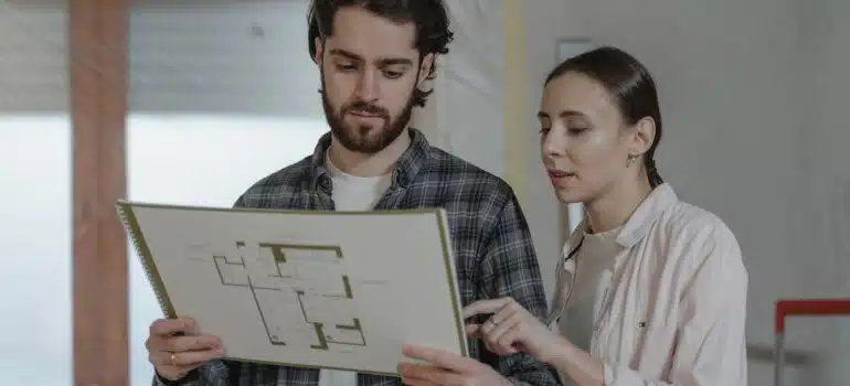 A couple looks at bluprints showing how to remodel your attic for living.