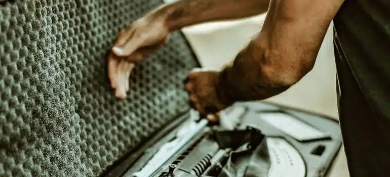 A man packing hunting rifle in a padded case