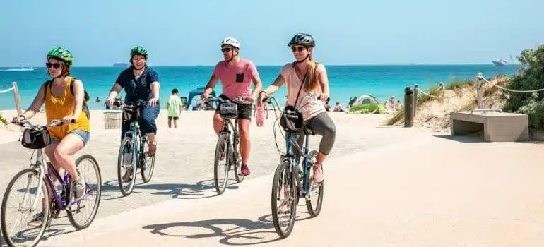 people riding a bike on a beach 