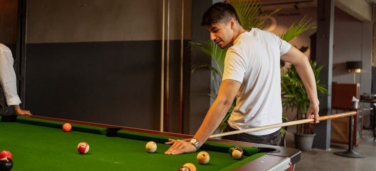 a man playing billiard thinking about loading a moving truck