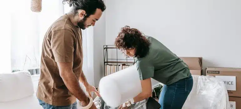 two people using foam bag to wrap the furniture