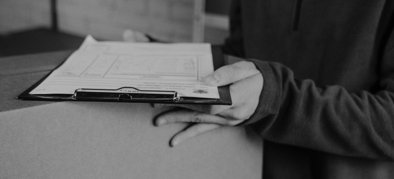 A Florida storage facility employee with a checklist and a box
