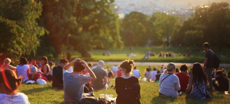 People relaxing in a sunny park, community vibe and green space for those who move to Wynwood in 2025.
