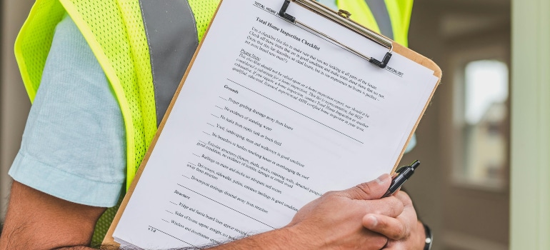 Home inspector holding a checklist clipboard, essential steps for first-time homebuyers in Bal Harbour during inspections.