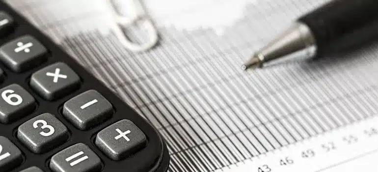 a calculator and a pen on some document 
