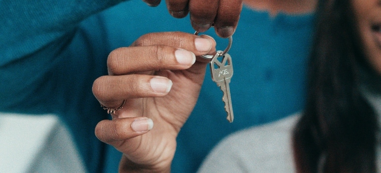 Close-up of a couple holding their new house key, symbolizing the start of their journey together.