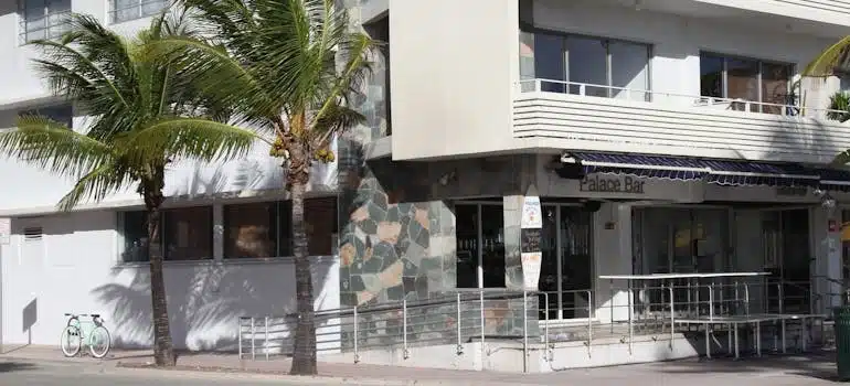 A condo building in Miami with two palms outside