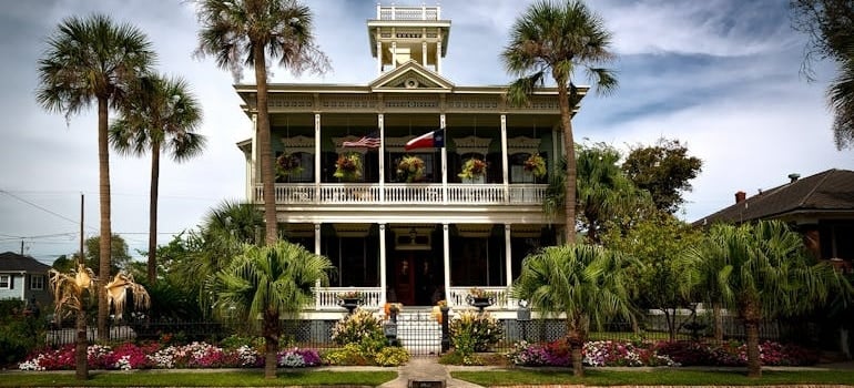 White Painted House With Green Palm Trees in Galveston, TX