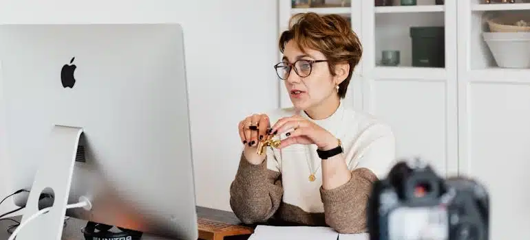 An elegant lady in eyeglasses hosting a video call