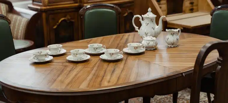 Vintage porcelain tea set on a wooden dining table before moving antique furniture long distance